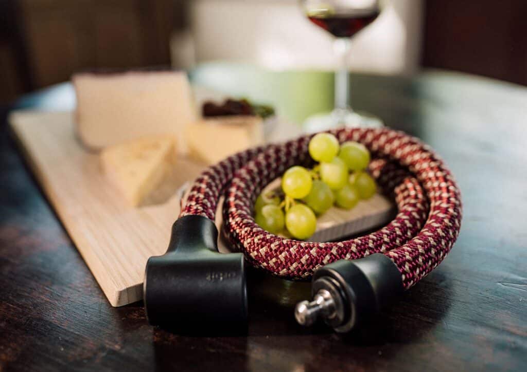 tex–lock orbit in chateau red lies wrapped together around grape umbel with cheese and wine in background
